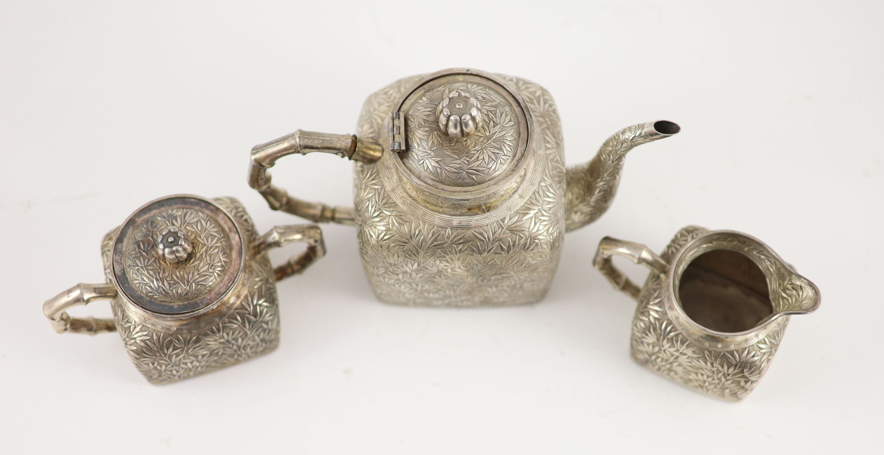 A late 19th/early 20th century Chinese Export silver three piece tea set (a.f.)